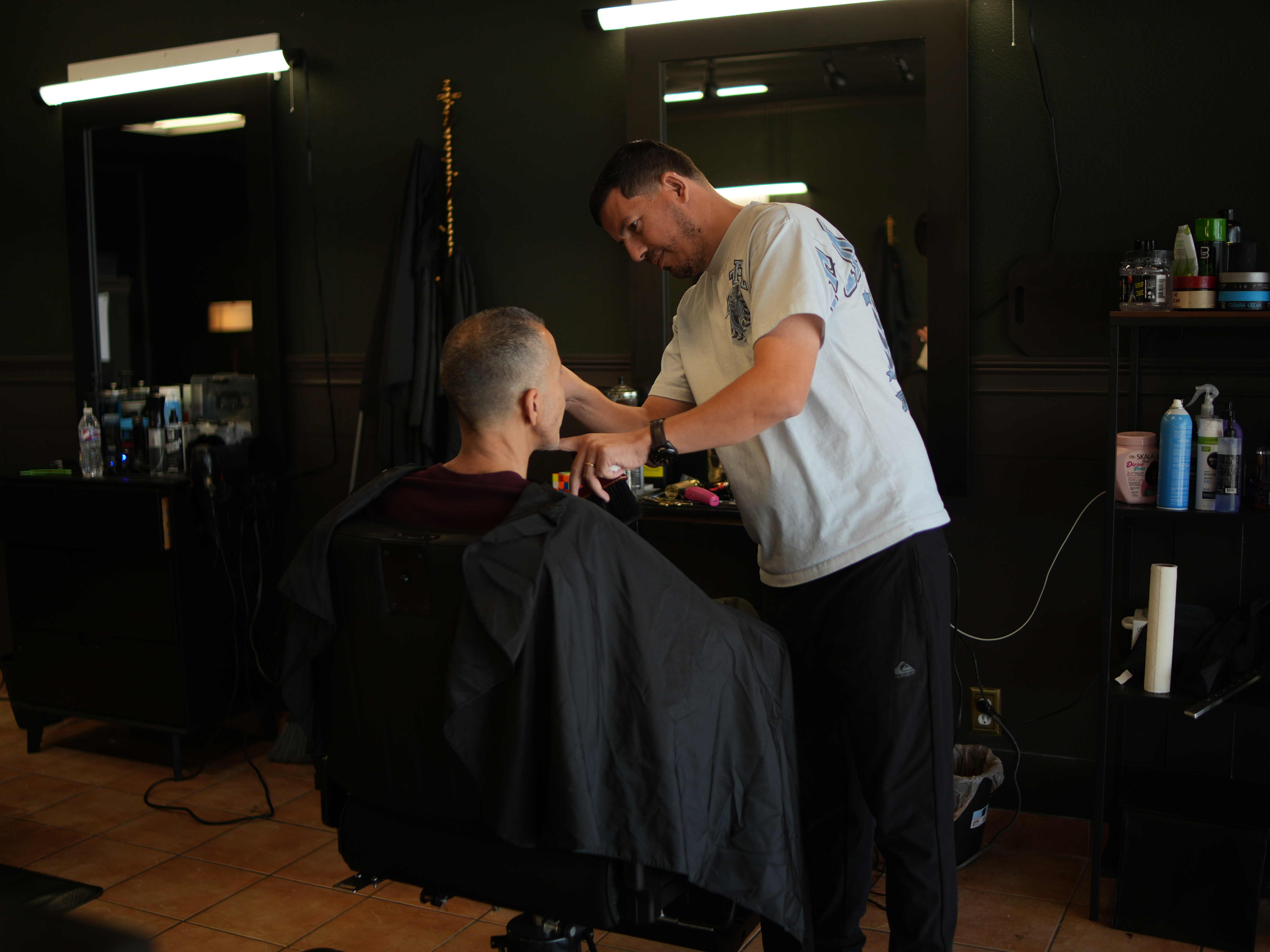 Barber working carefully with a client at a Hurst barber station